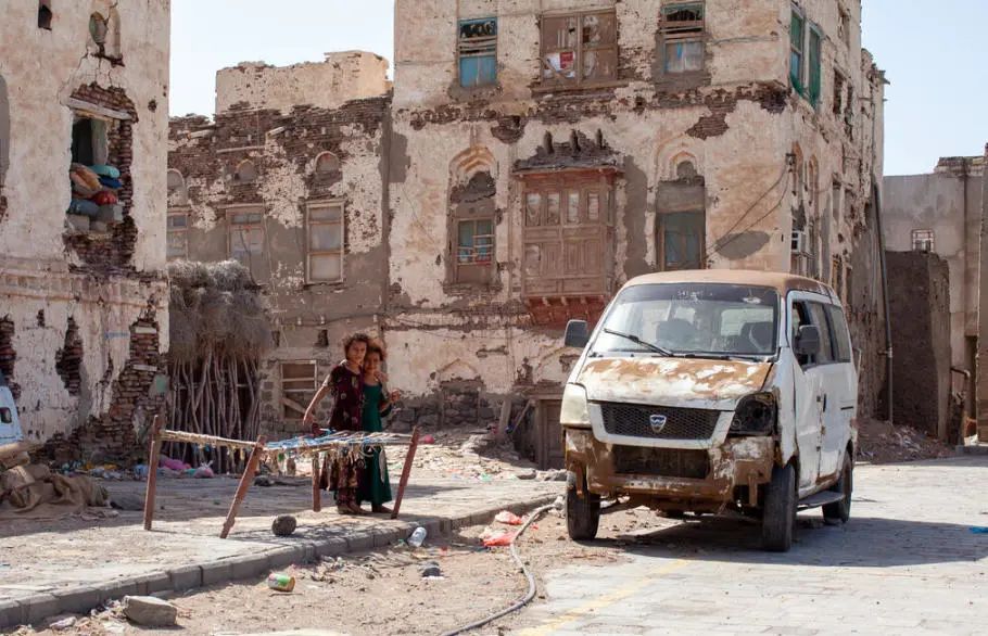 两名9岁的孩子在也门穆哈老城被冲突破坏的建筑物前玩耍。照片©WFP/Annabel Symington