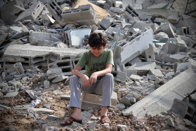 A boy next to the ruins of a building in Gaza city that was hit by a rocket.