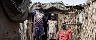 Nyaloth Duoth poses for a portrait with her children Dukan Kuony (C) and Nyamuch Kuoni (L) at her home in the Protection of Civilians (PoC) camp in Bentiu.