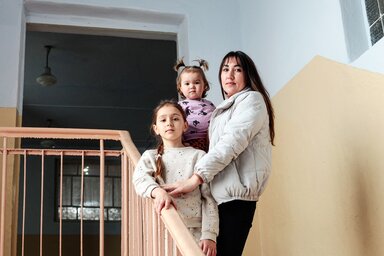 Mother Bobyleva Regina Petrivna, 32 years old, poses for a photograph with her children, Bobyleva Sofia Sergiivna, 1 year old, and Bobyleva Sabina Sergiivna, 8 years old, on a stairwell in the Sarata's Lyceum.