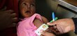 A little girl being tested for malnutrition with Mid Upper Arm Circumference test (MUAC) and receiving special fortified food from WFP at a WFP-supported clinic in North Kordofan.
