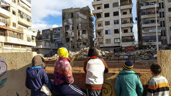 在叙利亚的哈马省，当地居民站在被地震破坏的建筑物附近。图片© WFP / Photolibrary