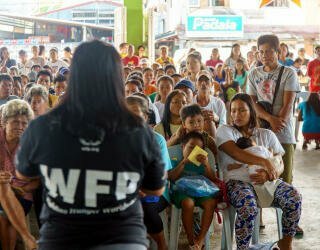 世界粮食计划署的工作人员向参加预测性融资项目的Irosin社区成员解释登记程序。照片：世界粮食计划署菲律宾办事处/Arete 