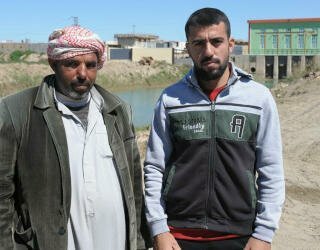 Mitib Ibrahim(左)和Mohammed Jama'a(右)来自不同的部落,他们在一起修复拉马迪一条灌溉渠时认识了彼此。照片:世界粮食计划署/David Orr
