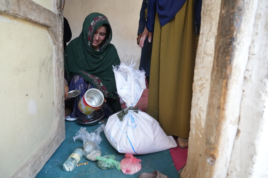 Woman in Kabul City sorts rubbish for chidlren to sell 