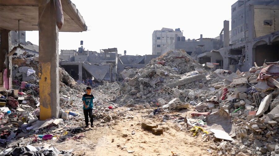 A boy picks his way through a destroyed neighbourhood in Gaza. Photo: WFP