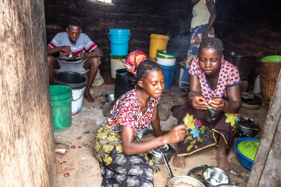 A family eats sitting on the ground in Zambia