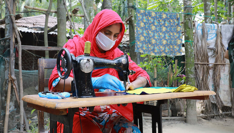在新冠疫情期间，世界粮食计划署在孟加拉国科克斯巴扎尔市（Cox's Bazar）开展生计改善项目，与来自收容社区的妇女及罗兴亚难民合作制作口罩。制作完成后由当地政府和人道主义机构分发，并向她们发放每月津贴，为她们提供市场工作培训和金融知识，并提供奖学金帮助她们创业。 照片 © WFP/Nalifa Mehelin