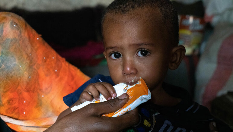 在也门，Sultan的母亲正在给他喂营养丰富的花生酱。他患有中度突发性营养不良。 得益于世界粮食计划署提供的补充营养的食物，Sultan体重有所增加，精力也比以前更加旺盛。但他仍然需要接受治疗。他的家人也获得了世界粮食计划署提供的面粉、干豆、油、糖和盐等粮食援助。 照片 © WFP/Mohammed Awadh